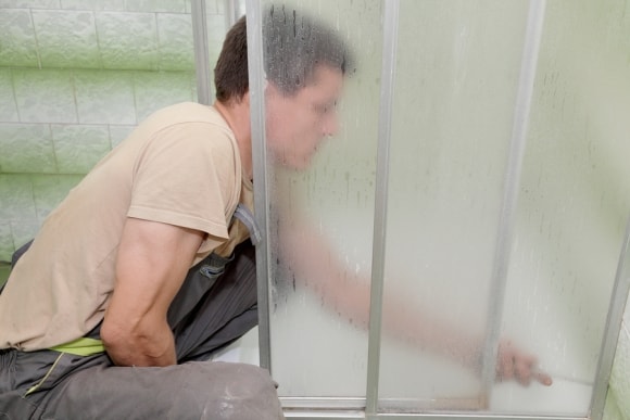 man installing shower door 