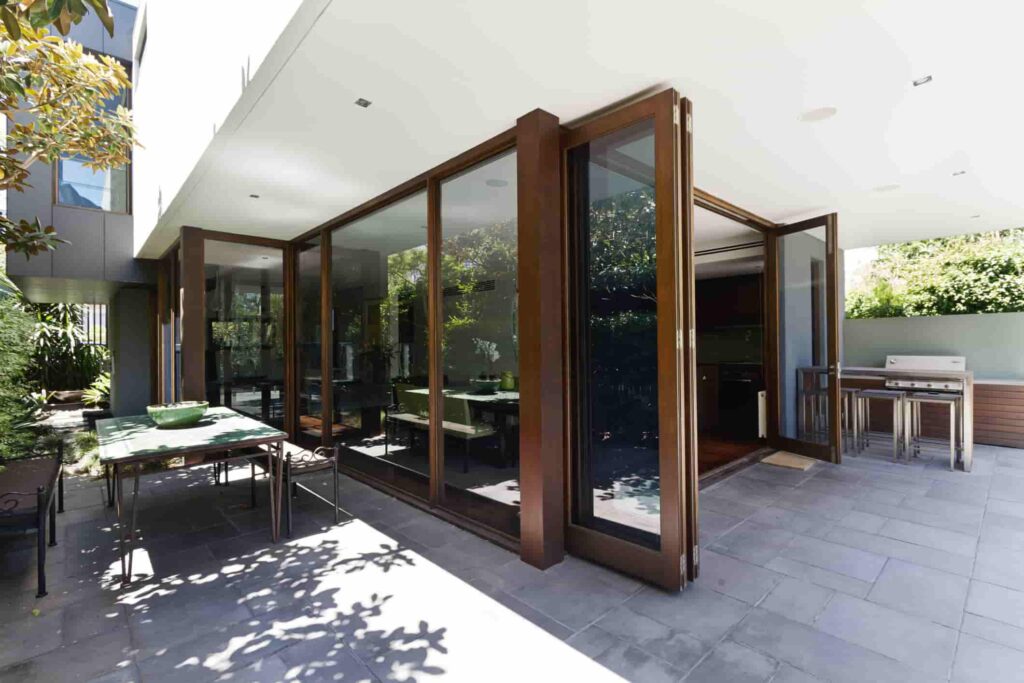 A cozy patio featuring a glass door and wooden furniture, perfect for relaxing in San Jose.